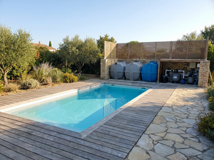 Moderne Garten-Poolanlage mit eingebettetem Becken, hellem Putz, Holzdeck und Kunststoff-Geräteraum.